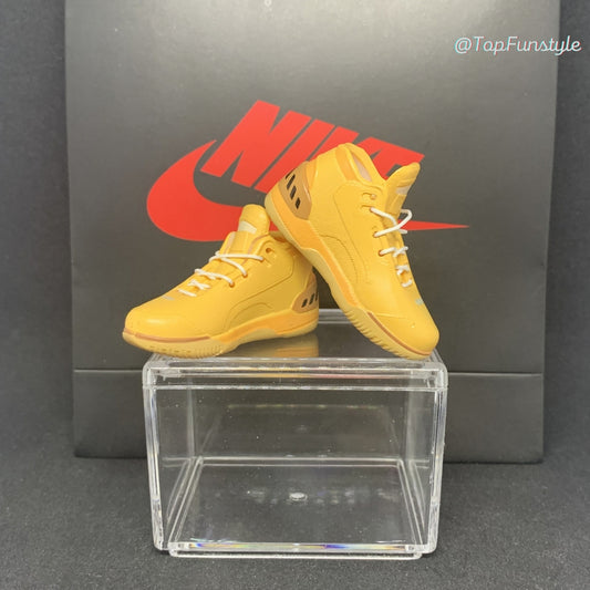 Mini sneakers LeBron 1 Wheat jaune blé posées sur la vitrine, lacets blancs et talon beige