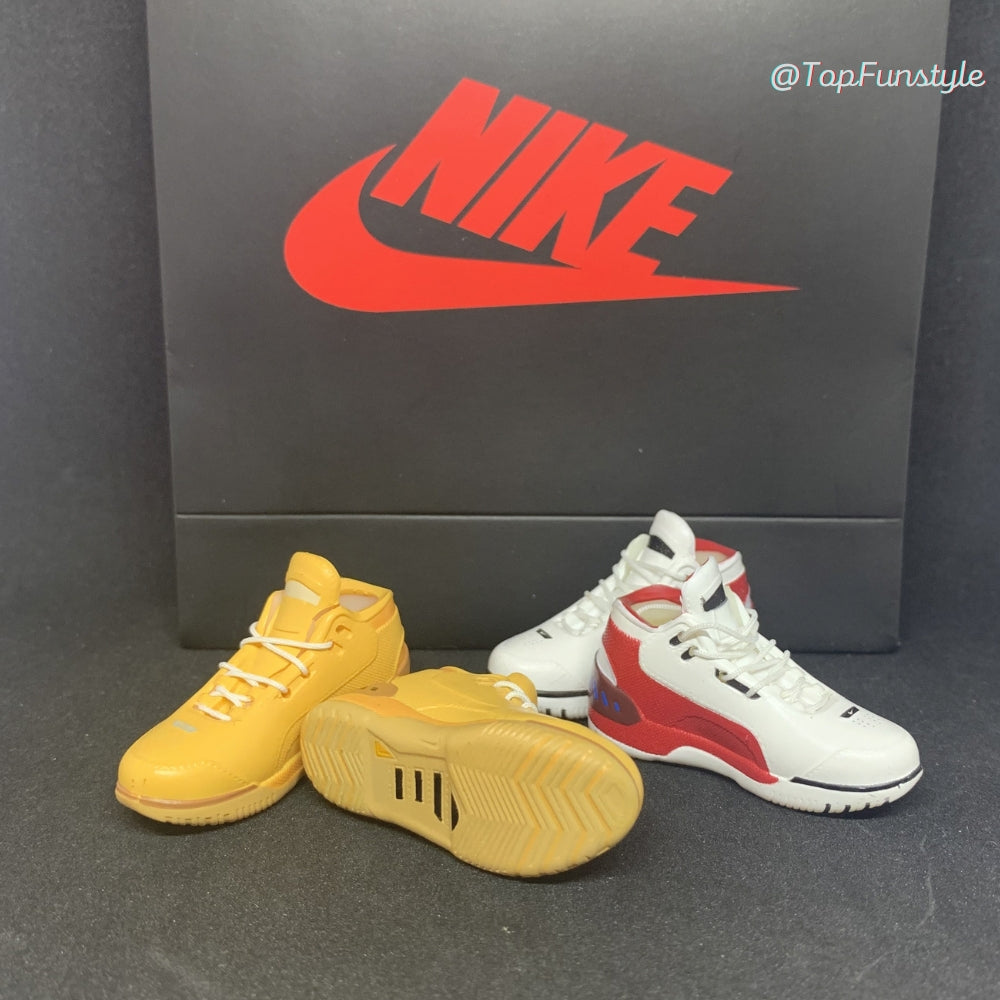 Les deux coloris LeBron 1 côte à côte : Wheat jaune blé et First Game blanc et rouge - miniatures décoratives