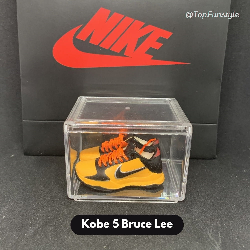 Mini sneakers Kobe 5 Bruce Lee jaune et noir à lacets orange dans leur vitrine transparente - miniature décorative