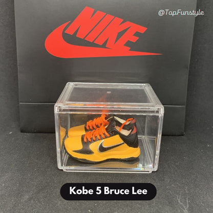 Mini sneakers Kobe 5 Bruce Lee jaune et noir à lacets orange dans leur vitrine transparente - miniature décorative