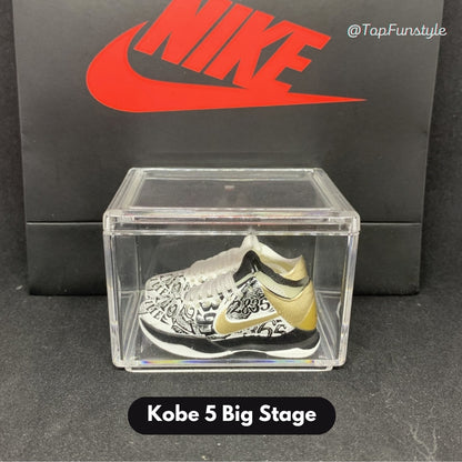 Mini sneakers Kobe 5 Big Stage Parade blanc, or et noir dans leur vitrine transparente - miniature décorative