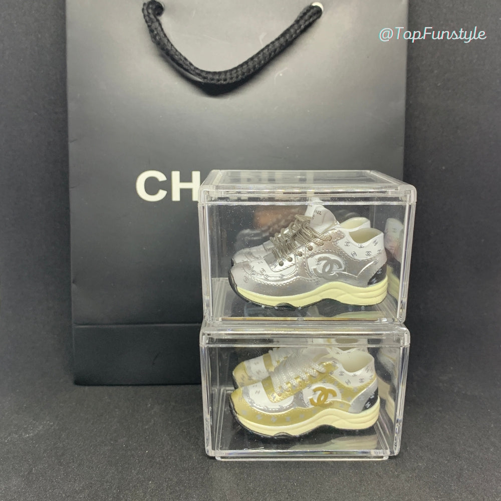 Mini sneakers Chanel CC doré et argenté empilés en vitrine - comparatif collection 3D