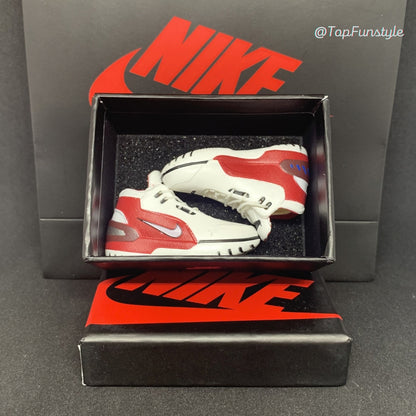 Paire de mini sneakers LeBron 1 First Game blanc et rouge dans sa boîte miniature à mousse noire